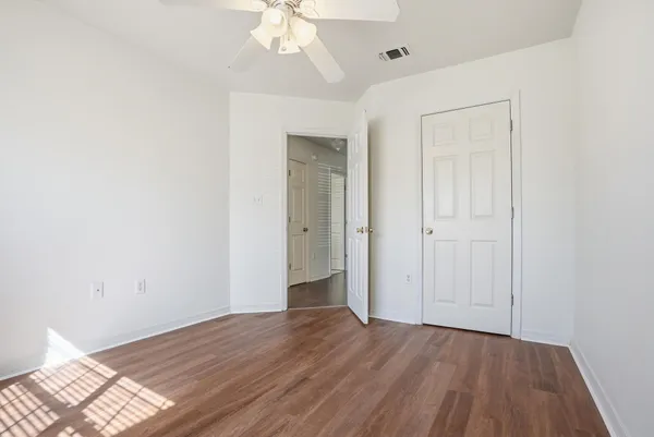 a view of an empty room with wooden floor