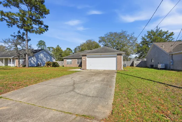 a view of a house with a yard and a large tree
