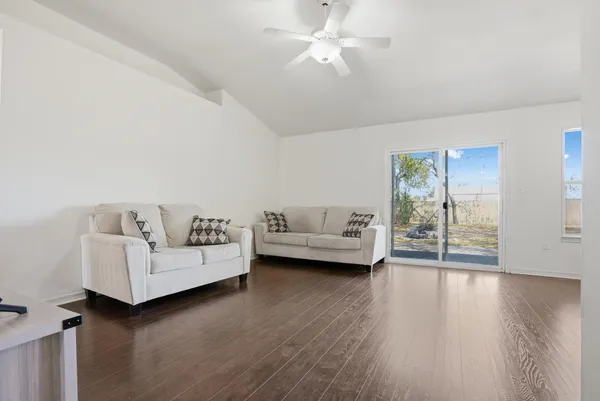 a living room with furniture and a wooden floor
