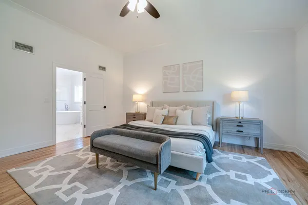 a spacious bedroom with a bed and a chandelier