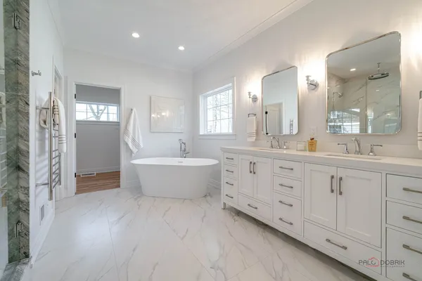 a bathroom with a double vanity sink a mirror and a bathtub