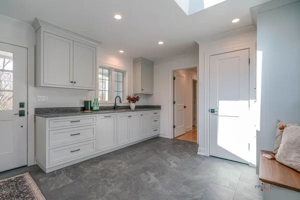 a kitchen with granite countertop white cabinets and white appliances
