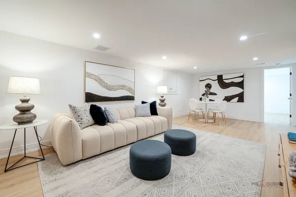 a living room with furniture a lamp and a large mirror