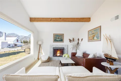 a living room with furniture a fireplace and a large window