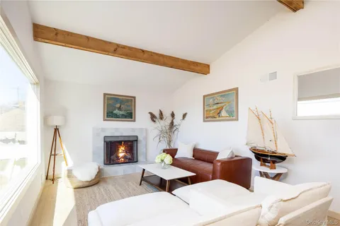 a living room with furniture a fireplace and a large window