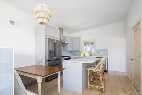 a kitchen with stainless steel appliances a table and chairs in it