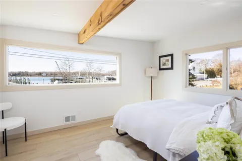 a bedroom with a bed and a window with chair