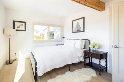 a bedroom with a bed table and a window