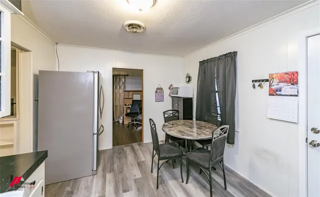 a view of a dining room with furniture wooden floor and a refrigerator