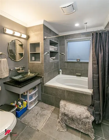 a bathroom with a tub sink and mirror