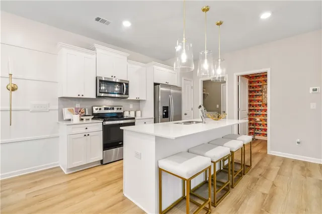 a kitchen with stainless steel appliances kitchen island granite countertop a sink stove and refrigerator