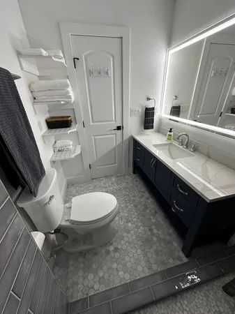 a spacious bathroom with a double vanity sink a mirror and a toilet