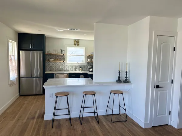 a kitchen with kitchen island white cabinets and stainless steel appliances