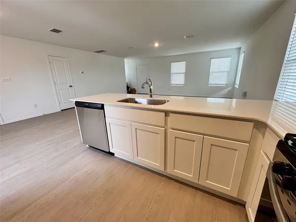 a room with a sink a mirror and cabinets