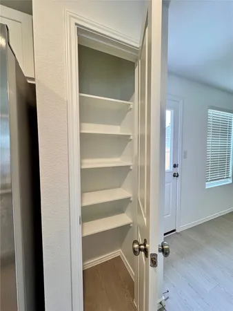 a view of a room with wooden floor and a window