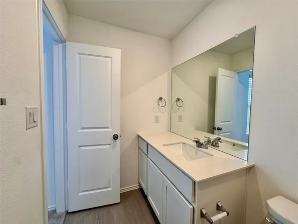 a bathroom with a sink mirror and vanity