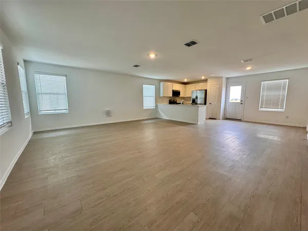a view of a livingroom with wooden floor and a window