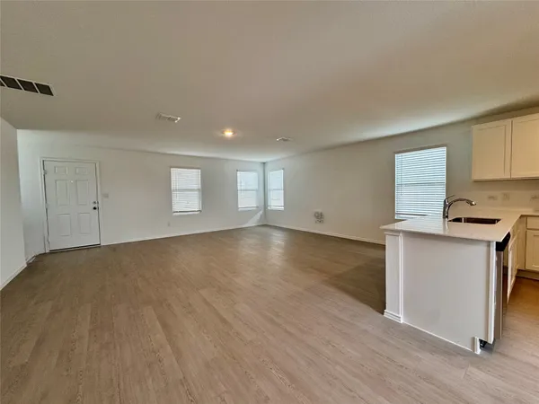 a view of empty room with wooden floor and window