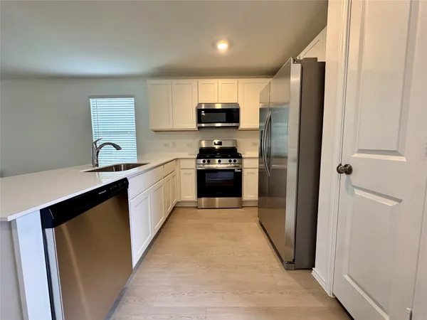 a kitchen with stainless steel appliances a refrigerator sink and cabinets