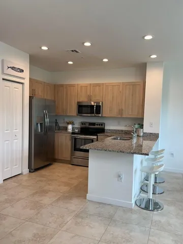 a kitchen with stainless steel appliances granite countertop a refrigerator and a stove top oven