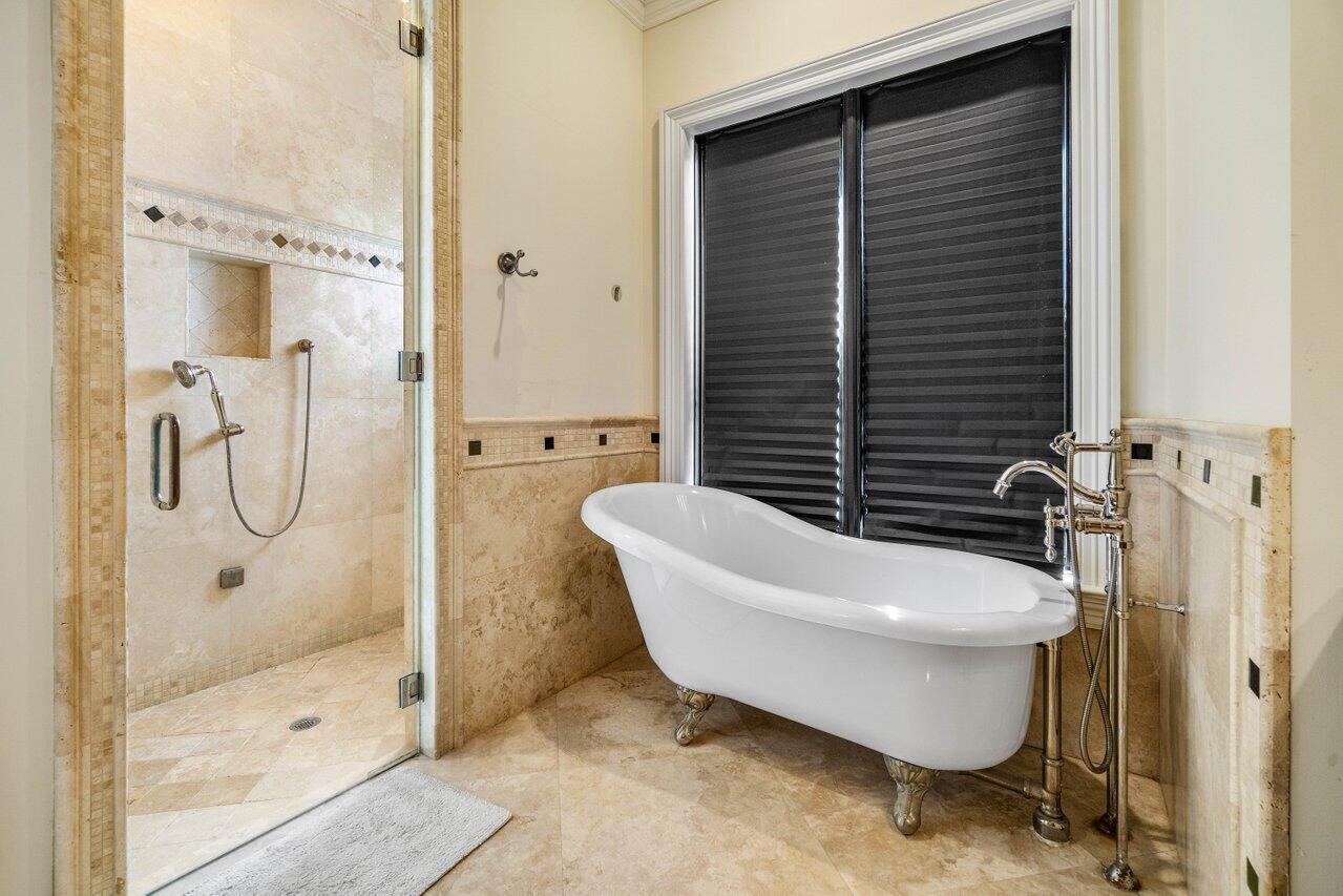 14140 Paradise Point Road Palm Beach Gardens, FL 33410 - Photo 65 of 148 a bathroom with a white bath tub a shower and a sink