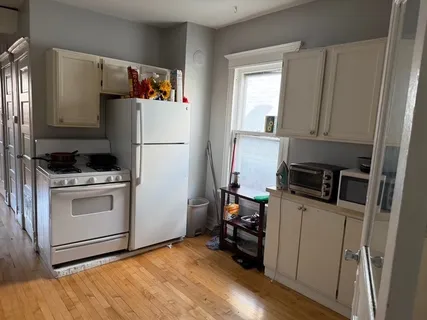 a kitchen with a refrigerator and a stove top oven