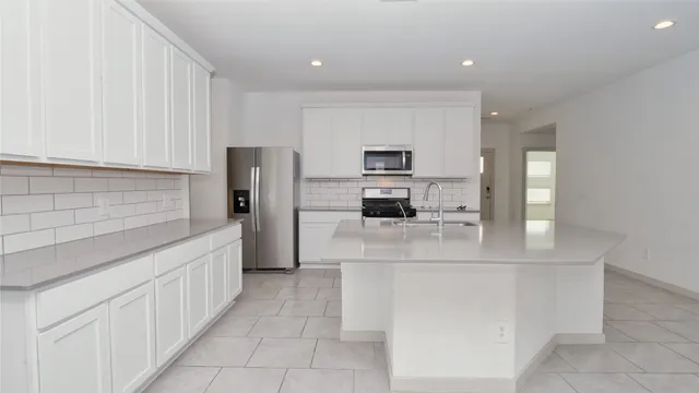 a kitchen with stainless steel appliances a refrigerator sink and cabinets