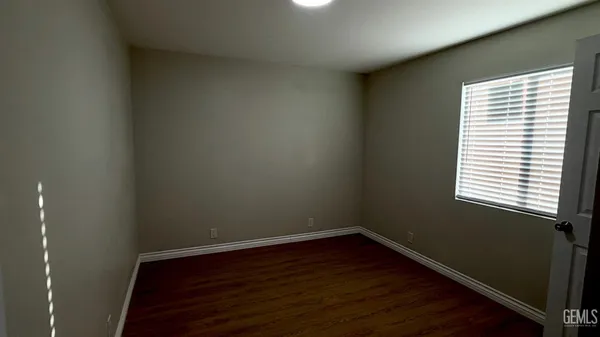 a small space with wooden floor and a window