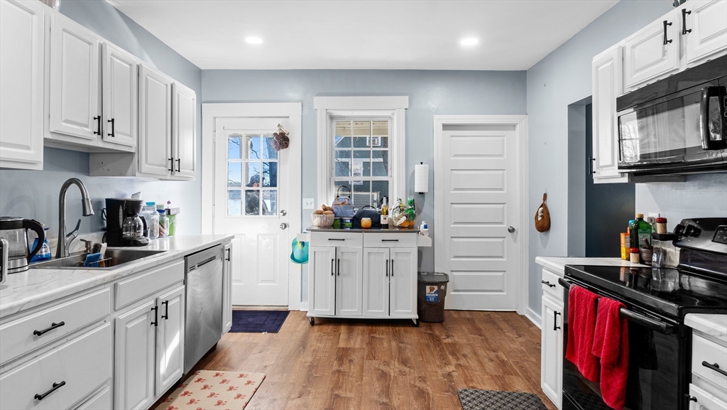 6 Crescent Street, Unit 6 Northbridge, MA 01588 - Photo 3 of 24 a kitchen with white cabinets and appliances