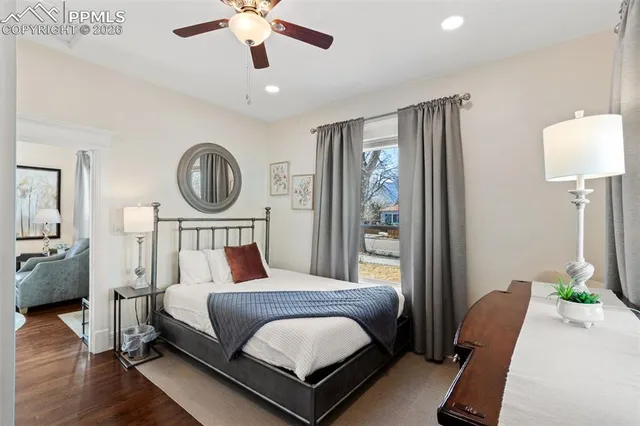 a bedroom with a bed chandelier and a window