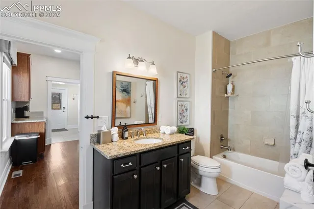 a bathroom with a granite countertop sink toilet mirror and bathtub