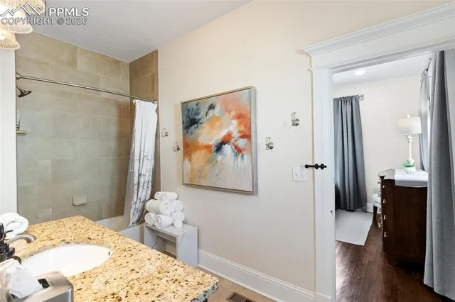 a bedroom with a bed and a painting on the wall