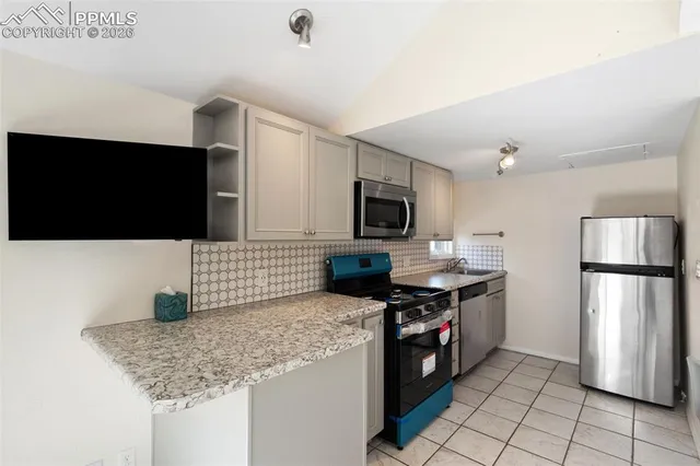 a kitchen with stainless steel appliances granite countertop a refrigerator and a stove top oven