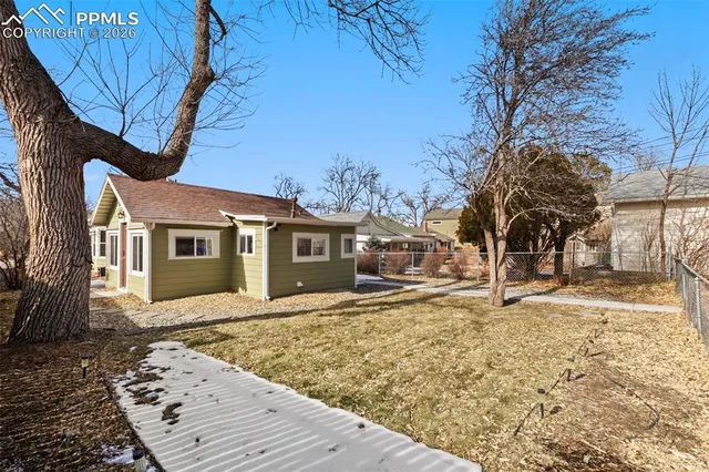 a front view of a house with a yard covered in snow