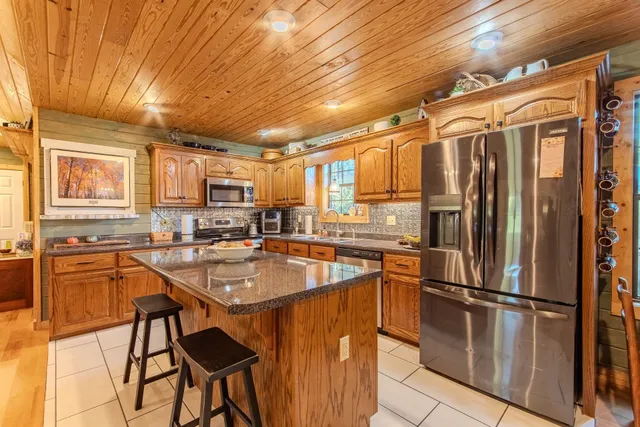 a large kitchen with stainless steel appliances granite countertop a sink and cabinets
