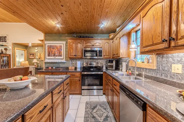 a living room with stainless steel appliances furniture stove and a kitchen view