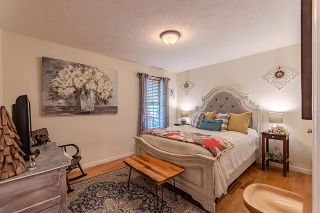 a bedroom with a bed a mirror and dresser