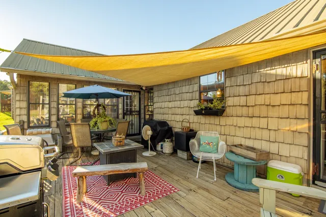 a view of patio with a table and chairs under an umbrella