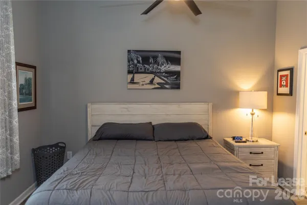 a bedroom with a bed and a lamp on dresser