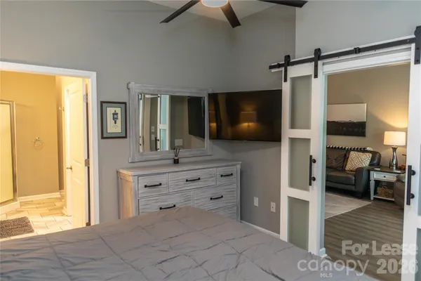 a room with a bed and a view of living room