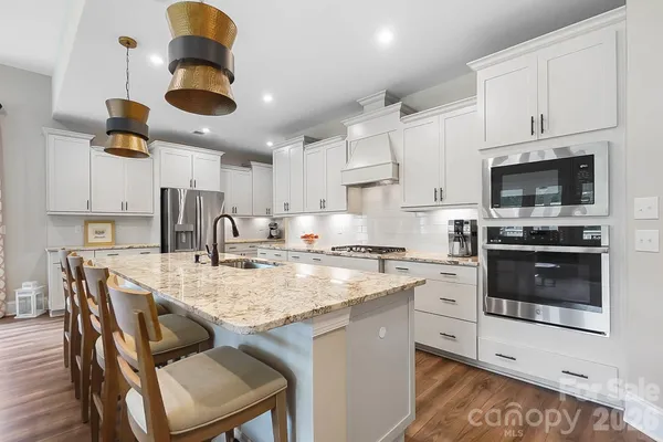a kitchen with a stove a sink and cabinets