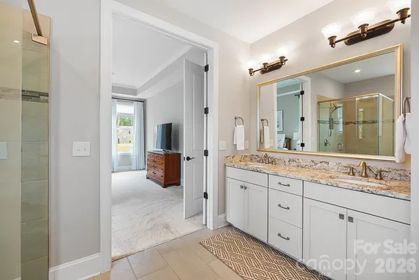 a spacious bathroom with a double vanity sink a mirror and a shower