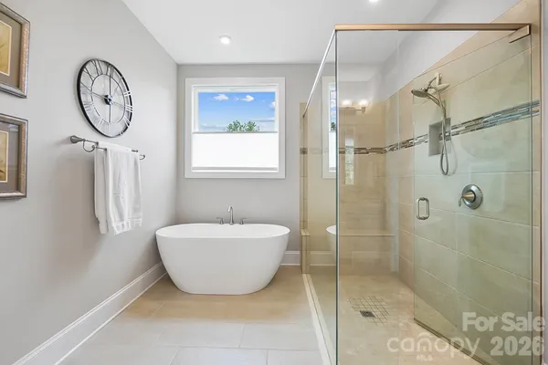 a bathroom with a toilet a sink a mirror and shower