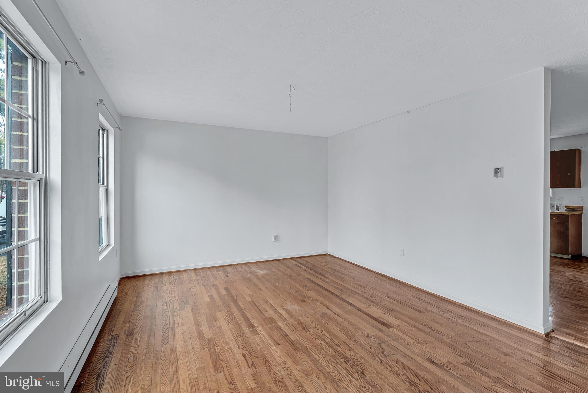 210 Brunswick Road Stephens City, VA 22655 - Photo 3 of 18 an empty room with wooden floor and windows