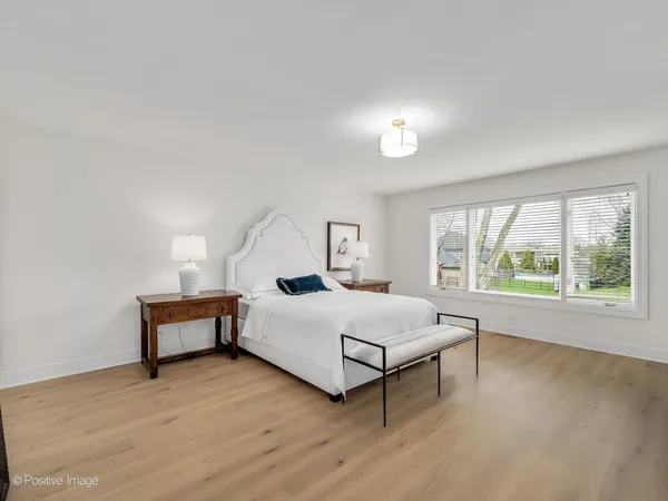 a bedroom with a bed and a large window