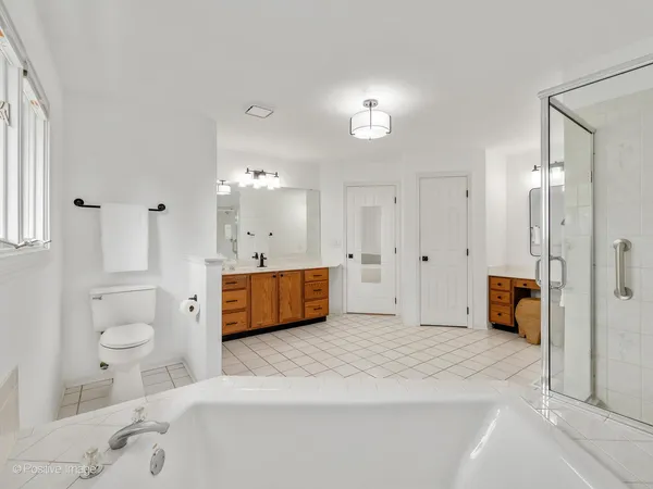 a spacious bathroom with a tub sink shower and mirror
