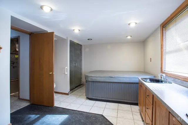a bathroom with a granite countertop bathtub a sink and a large mirror