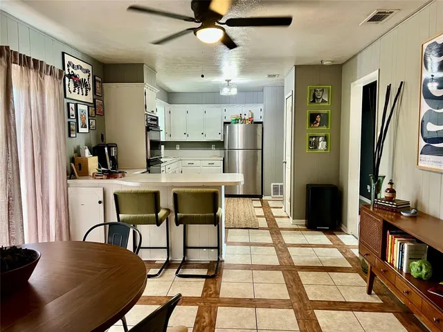 a kitchen with stainless steel appliances kitchen island granite countertop a refrigerator and microwave