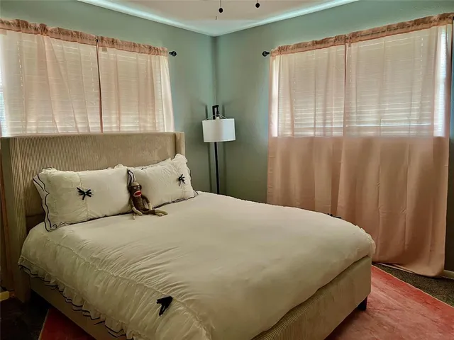 a large bed sitting in a bedroom next to a window