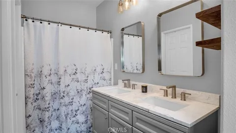 a bathroom with a sink vanity mirror and shower